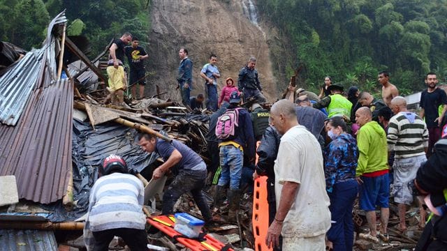 Rettungskräfte und Einwohner suchen zwischen den Trümmern der weggerissenen Häuser nach Überlebenden. Rettungskräfte und Einwohner suchen zwischen den Trümmern der weggerissenen Häuser nach Überlebenden.