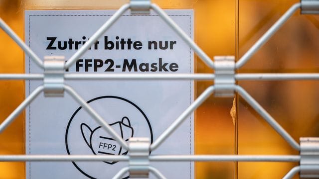 Ein Schild am Eingang eines Geschäfts weist auf das Tragen einer FFP2-Maske hin (Symbolbild): Wann wird in Deutschland gelockert?