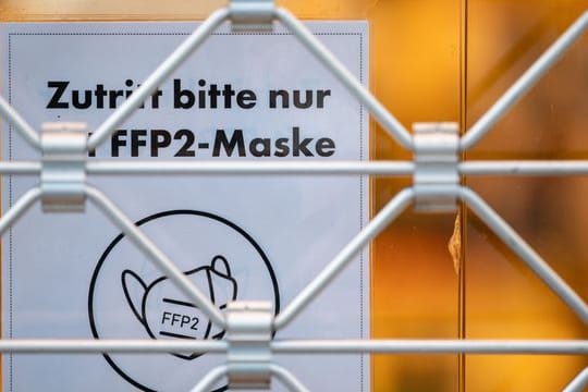 Ein Schild am Eingang eines Geschäfts weist auf das Tragen einer FFP2-Maske hin (Symbolbild): Wann wird in Deutschland gelockert?