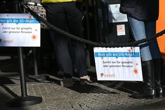 Vor einem Geschäft für Bastelbedarf in der Mainzer Innenstadt hängen Hinweisschilder mit der Aufschrift "Hier gilt die 2G-Regel.