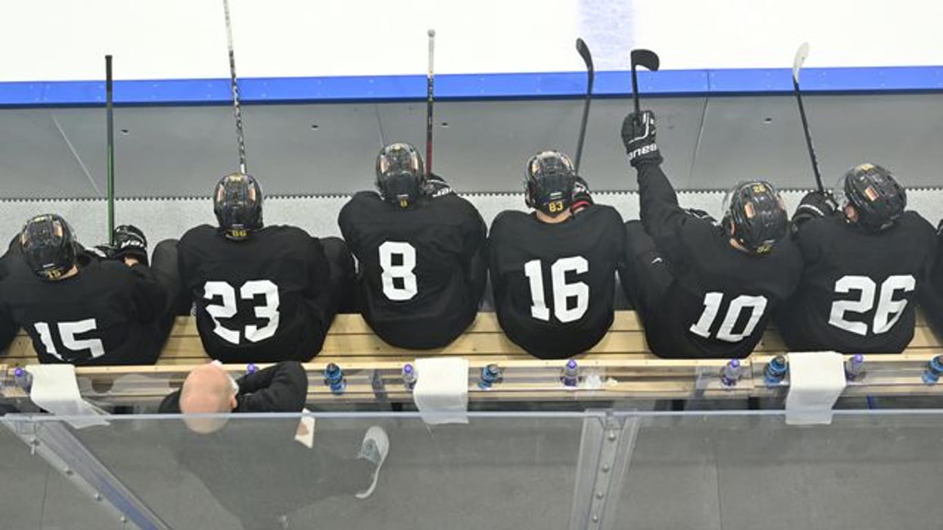 Spieler der deutschen Eishockey-Nationalmannschaft sitzen bei einer Trainingseinheit auf der Bank.