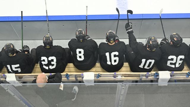 Spieler der deutschen Eishockey-Nationalmannschaft sitzen bei einer Trainingseinheit auf der Bank. Spieler der deutschen Eishockey-Nationalmannschaft sitzen bei einer Trainingseinheit auf der Bank.