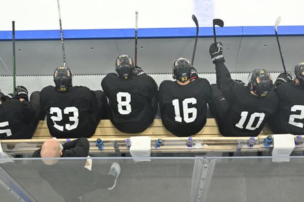 Spieler der deutschen Eishockey-Nationalmannschaft sitzen bei einer Trainingseinheit auf der Bank.
