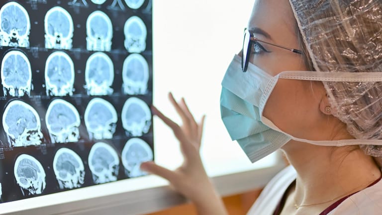 Ärztin schaut Röntgenbilder eines Kopfes an (Symbolbild): Der Nagel verfehlte das Gehirn der Frau.