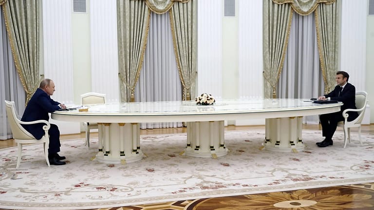 Treffen in Kreml: Putin und Macron sitzen in Moskau an einem großen Tisch.