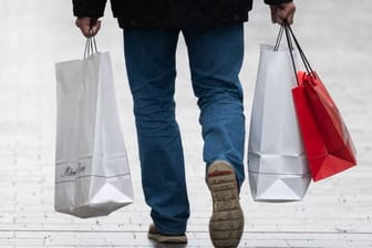 Ein Mann läuft mit Einkaufstaschen durch die Innenstadt von Hannover.