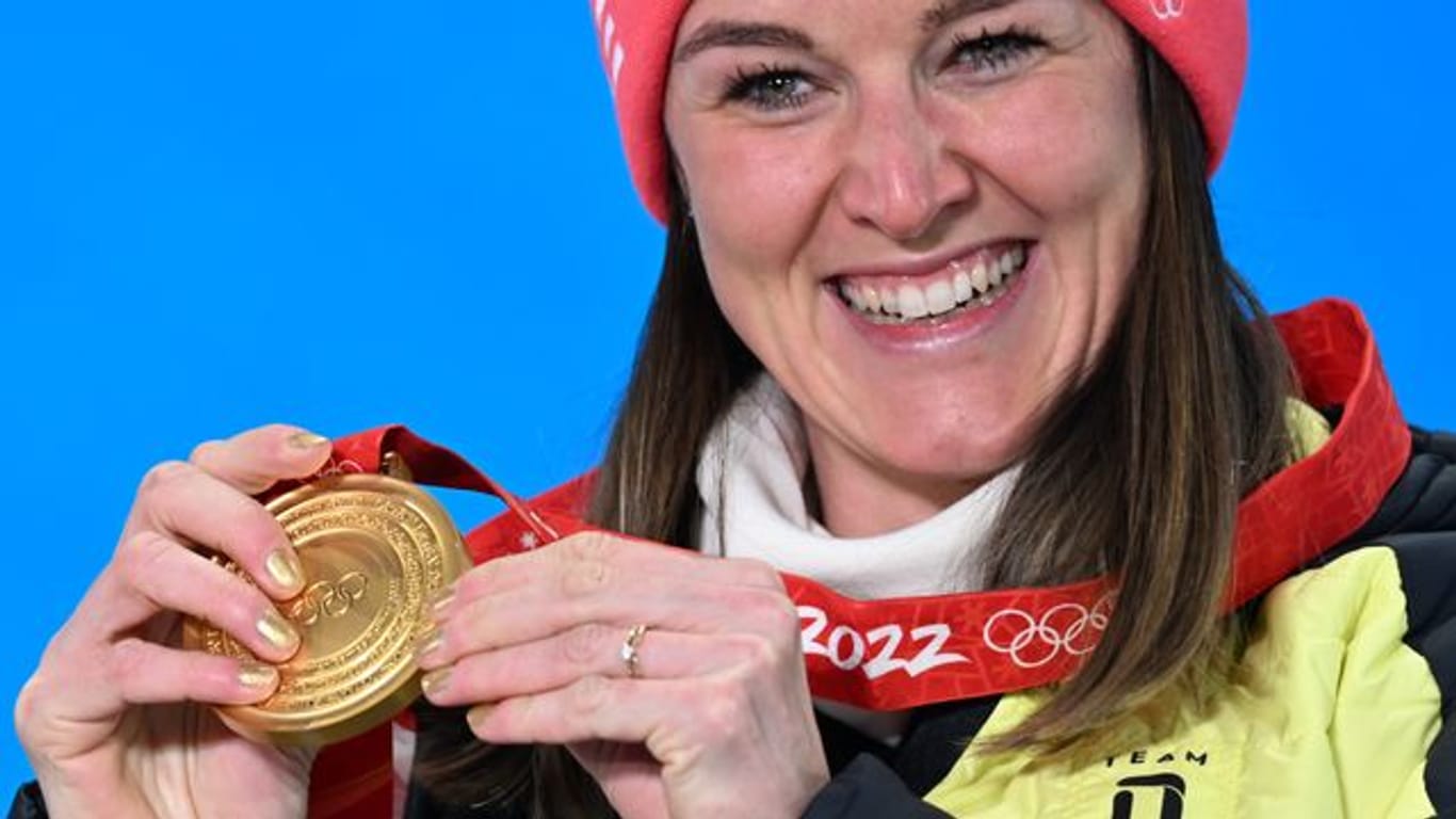 Biathletin Denise Herrmann zeigt stolz ihre Goldmedaille.