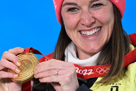 Biathletin Denise Herrmann zeigt stolz ihre Goldmedaille.