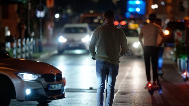 Auf dem E-Scooter durch die Nacht - ohne Helm. Auf dem E-Scooter durch die Nacht - ohne Helm.