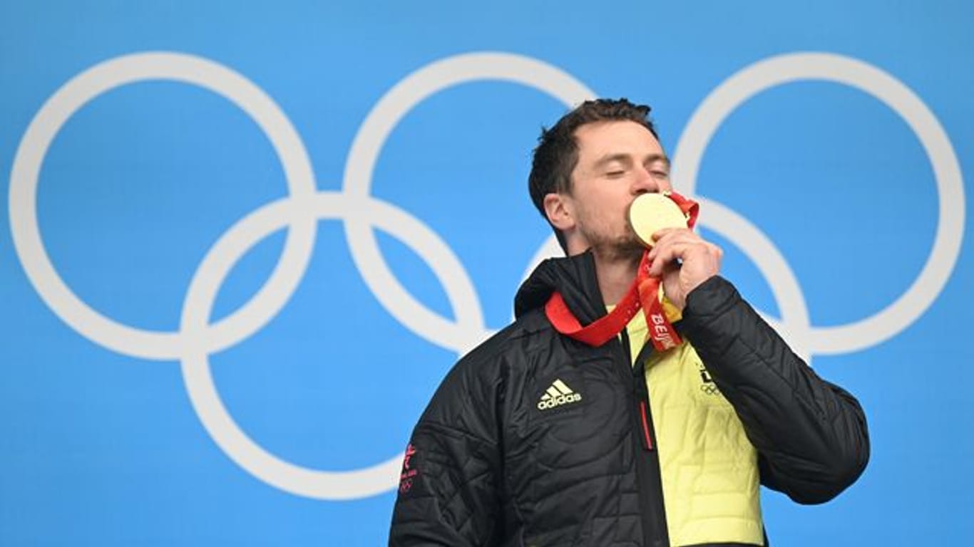 Der 35-jährige Rodler Johannes Ludwig feiert mit seiner Goldmedaille auf dem Podium.