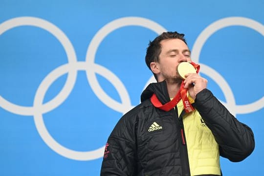 Der 35-jährige Rodler Johannes Ludwig feiert mit seiner Goldmedaille auf dem Podium.