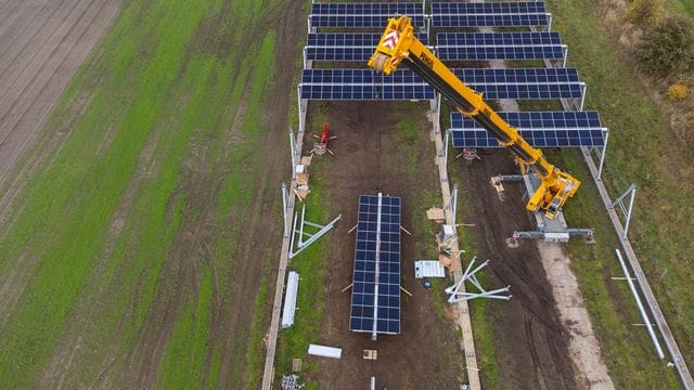 Mit einem Kran wird eine Agrar-Photovoltaik-Anlage in Niedersachsen montiert. Mit einem Kran wird eine Agrar-Photovoltaik-Anlage in Niedersachsen montiert.