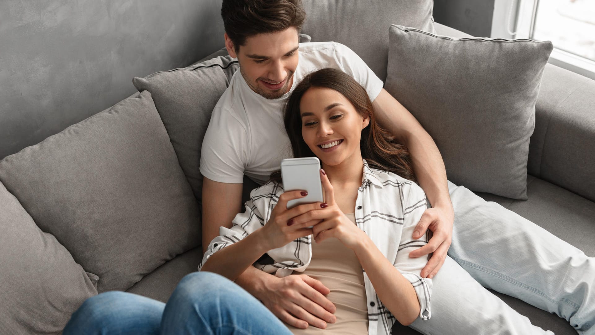 Ein Paar sitzt entspannt auf dem Sofa (Symbolbild): Wer sich auch bei der Steuer zusammentut, kann so manchen Vorteil mitnehmen.