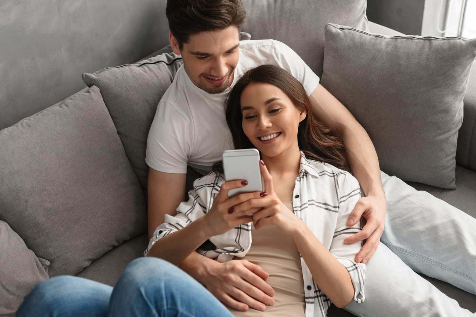 Ein Paar sitzt entspannt auf dem Sofa (Symbolbild): Wer sich auch bei der Steuer zusammentut, kann so manchen Vorteil mitnehmen.