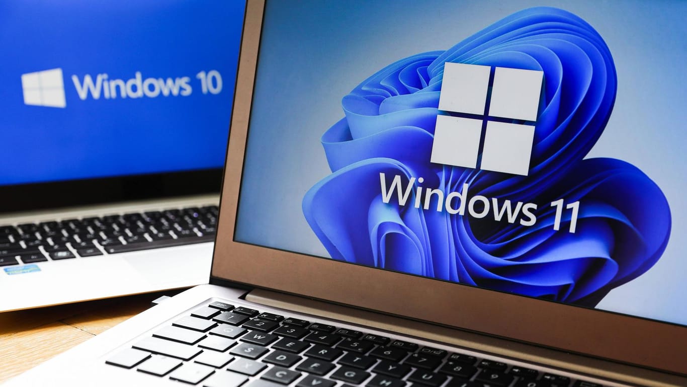 Windows 11 Vs. Windows 10 Windows 11 and Windows 10 operating system logos are displayed on laptop screens for illustrat
