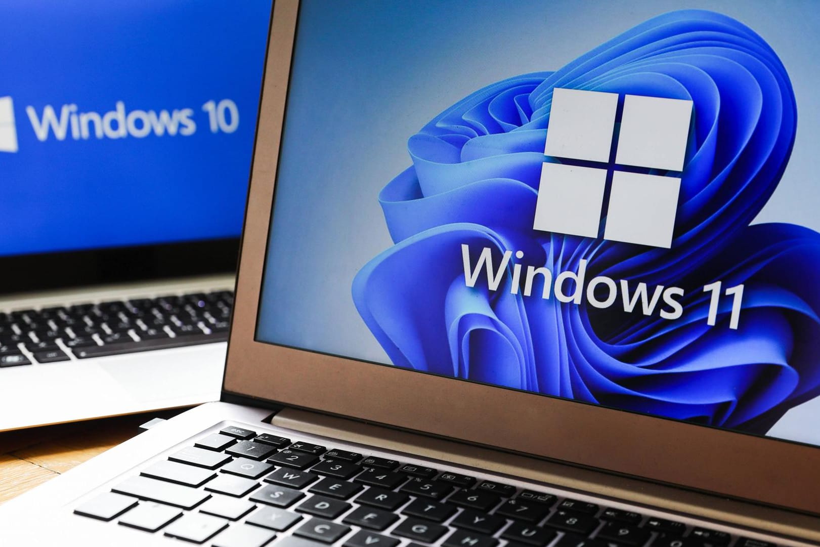 Windows 11 Vs. Windows 10 Windows 11 and Windows 10 operating system logos are displayed on laptop screens for illustrat