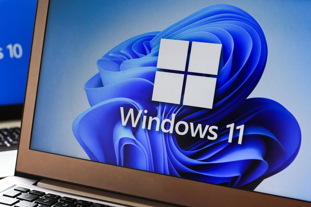 Windows 11 Vs. Windows 10 Windows 11 and Windows 10 operating system logos are displayed on laptop screens for illustrat