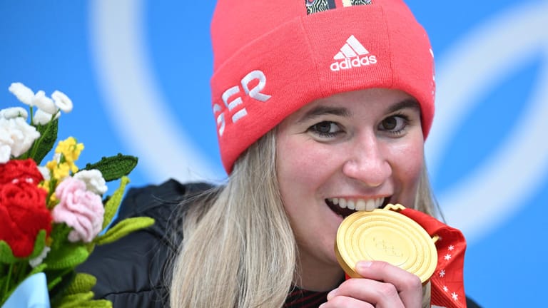 Schmeckt nach Gold: Natalie Geisenberger beißt in ihre Medaille.