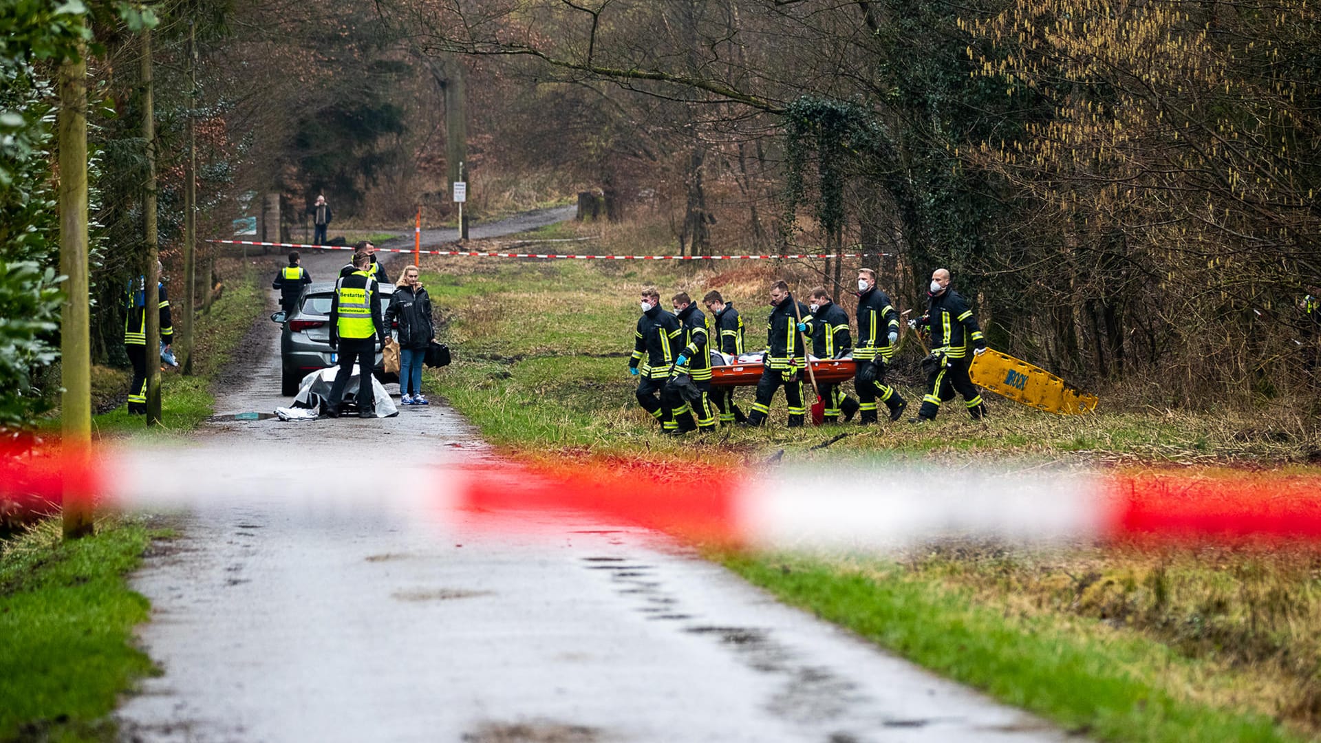 Einsatzkräfte tragen den Leichnam aus dem Waldstück: Eine Spaziergängerin hatte die leblose Person entdeckt.