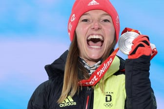 Da konnte sie noch lachen: Katharina Althaus präsentiert bei der Medaillenübergabe stolz Olympia-Silber.