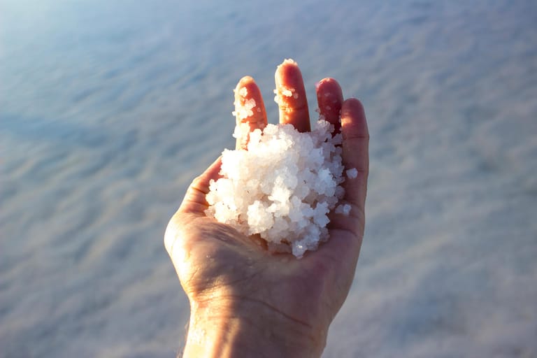 Man holding salts in salt lake in Aksaray, Turkey