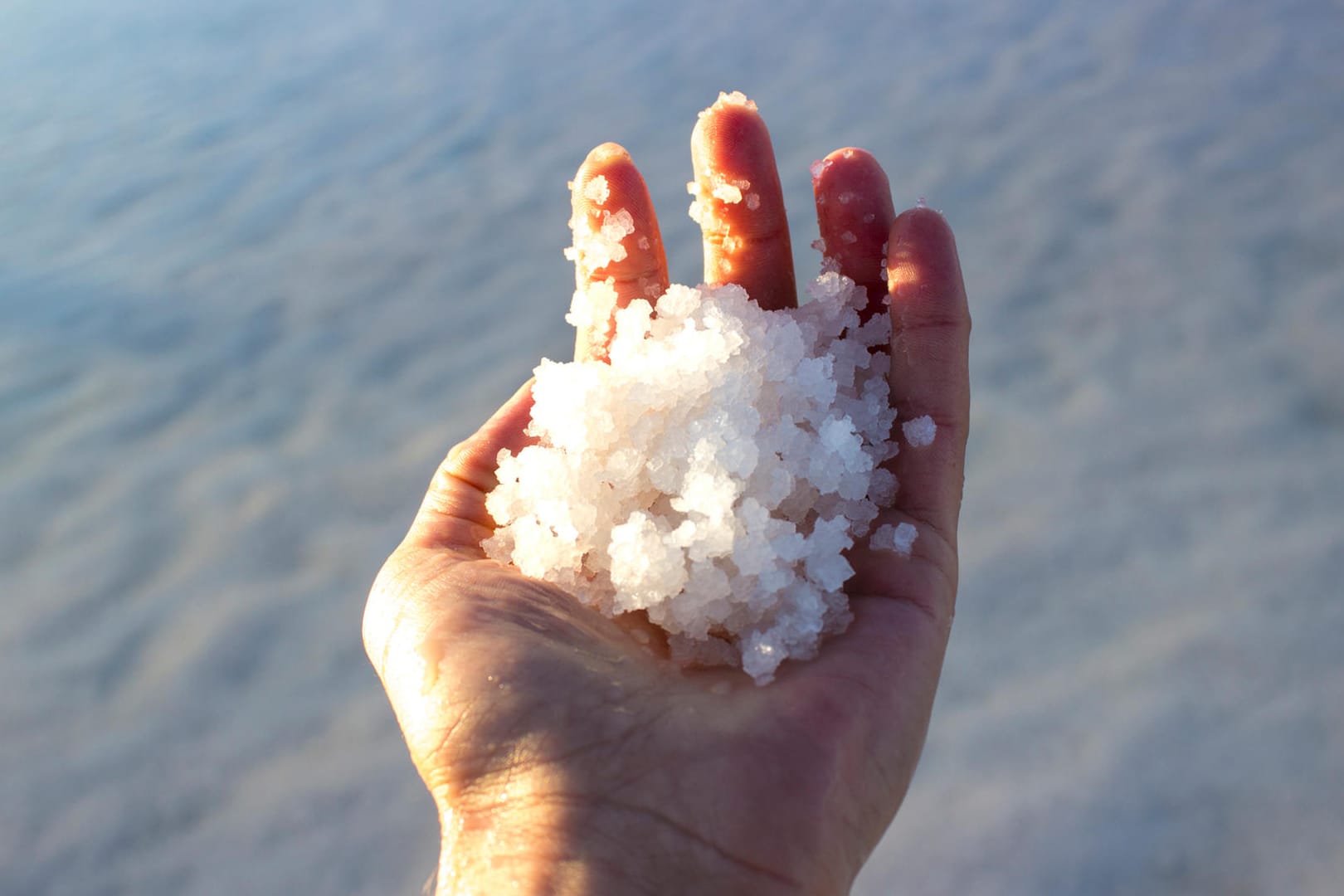 Man holding salts in salt lake in Aksaray, Turkey