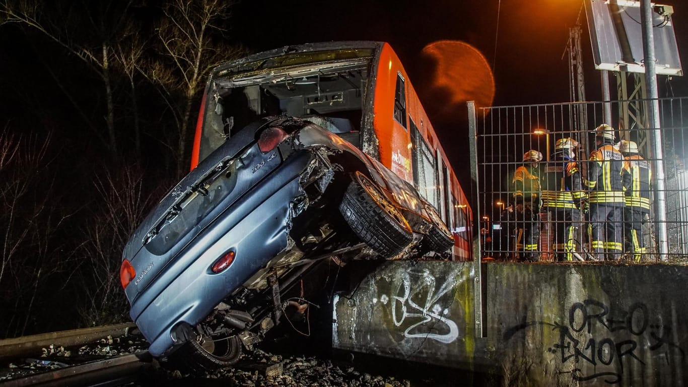 Einsatzkräfte der Feuerwehr bei den verunfallten Fahrzeugen: Eine Regionalbahn ist am Freitagmorgen bei Herrenberg mit einem Auto zusammengestoßen.