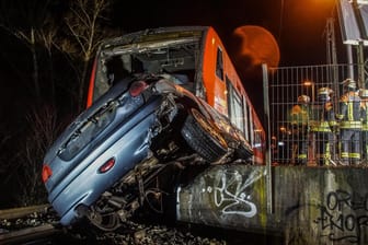 Einsatzkräfte der Feuerwehr bei den verunfallten Fahrzeugen: Eine Regionalbahn ist am Freitagmorgen bei Herrenberg mit einem Auto zusammengestoßen.