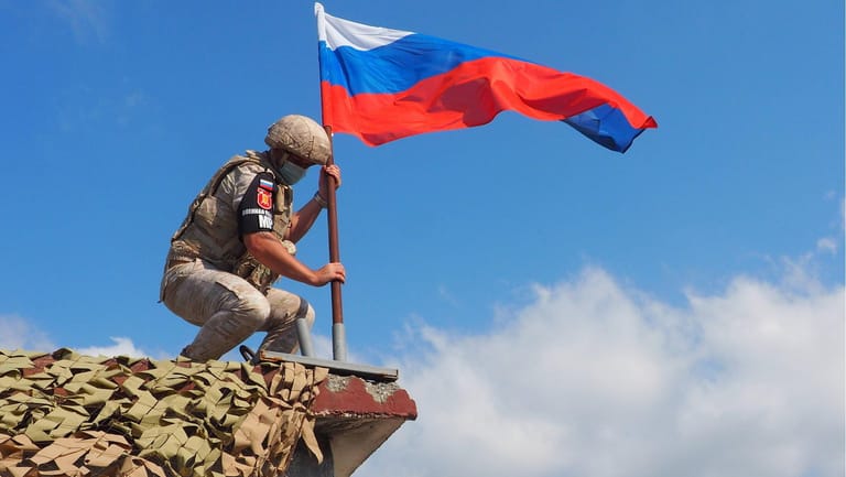 Ein russischer Soldat hisst in Syrien die Landesflagge: "Die Erfolge in Syrien waren hauptsächlich den Opfern der Söldner geschuldet". (Symbolfoto)