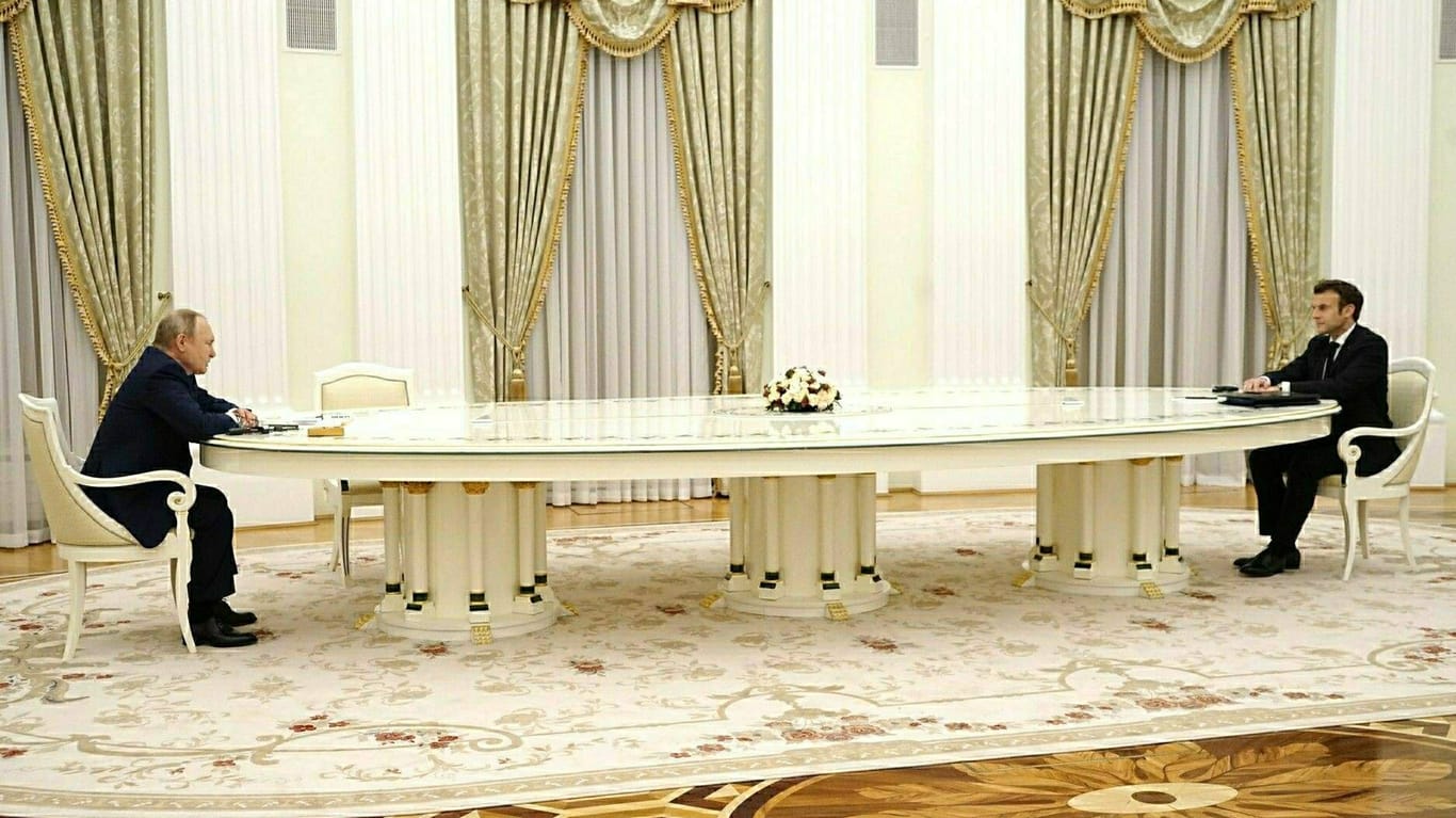 Putin und Macron: Die beiden saßen sich an einem langen Tisch gegenüber.