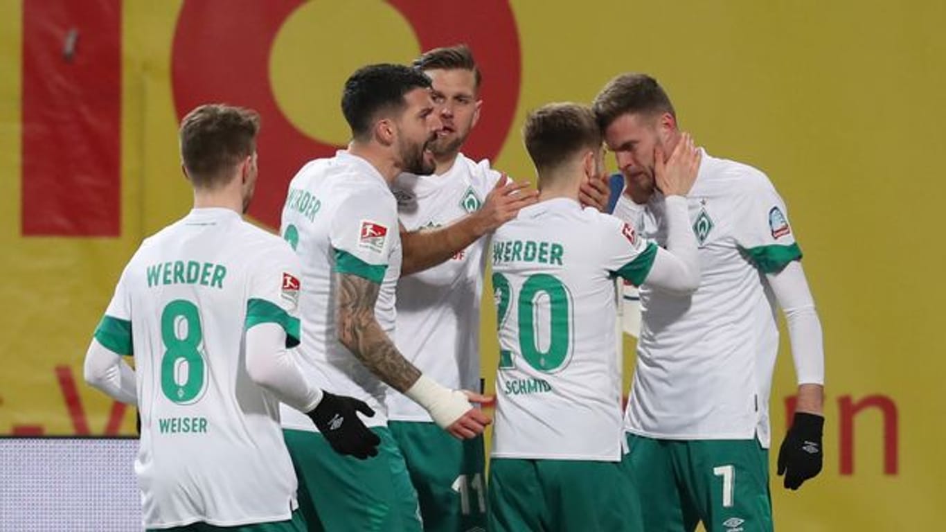 Die Spieler von Werder Bremen bejubeln Marvin Ducksch (r), den Torschützen des 1:0 in Rostock.