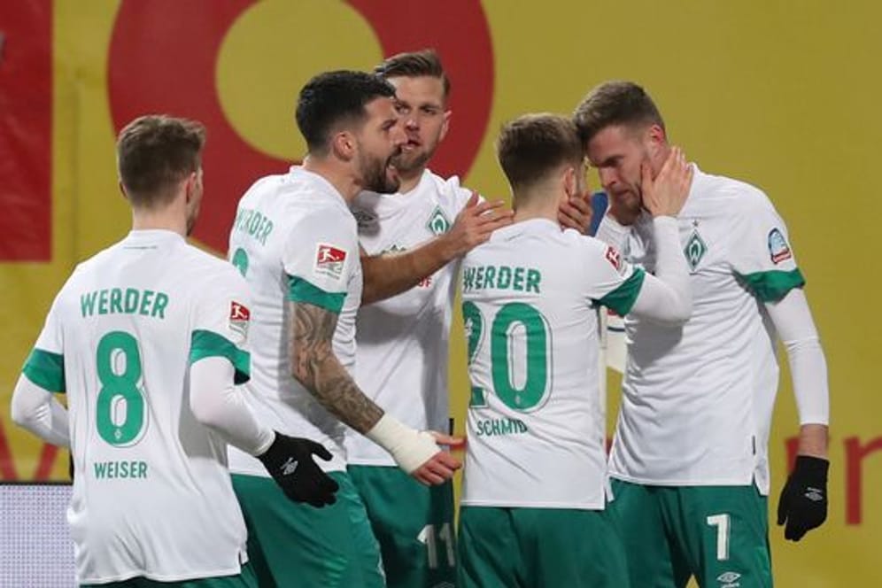 Die Spieler von Werder Bremen bejubeln Marvin Ducksch (r), den Torschützen des 1:0 in Rostock.
