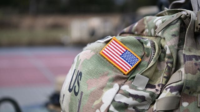 Ein Aufnäher in Form der US-Flagge ist an der Uniform eines US-Soldaten angebracht. Ein Aufnäher in Form der US-Flagge ist an der Uniform eines US-Soldaten angebracht.