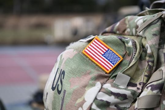 Ein Aufnäher in Form der US-Flagge ist an der Uniform eines US-Soldaten angebracht.