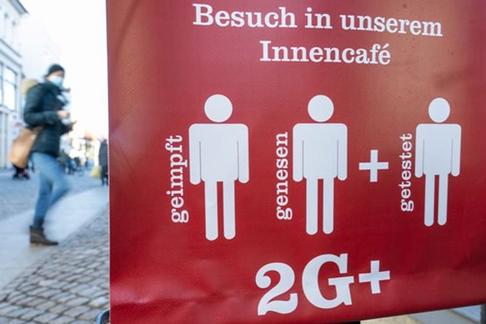 Ein Schild weist auf die 2G Plus Regel in einem Café im Ostseebad auf Rügen hin.