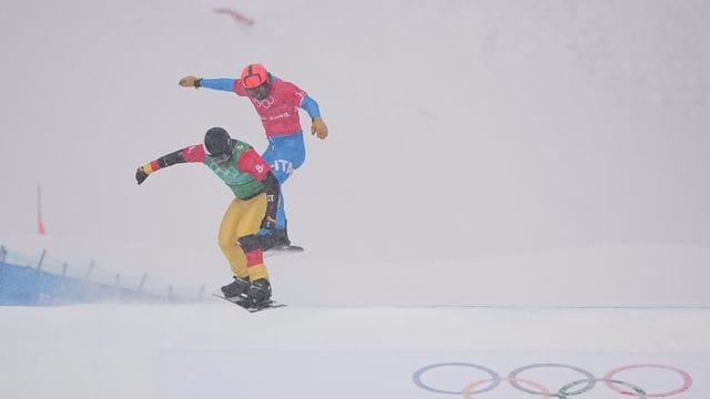 Snowboardcrosser Martin Nörl (l) rast beim Team-Wettbewerb über die Piste.