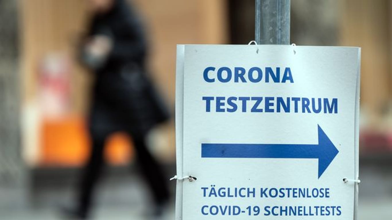 Ein Pappschild weist die Richtung zu einem Corona-Testzentrum in Düsseldorf.