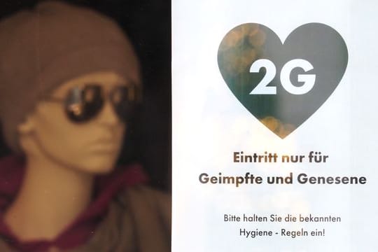 Ein Schild weist die Kunden eines Modegeschäfts in Potsdam auf die 2G-Regel hin.