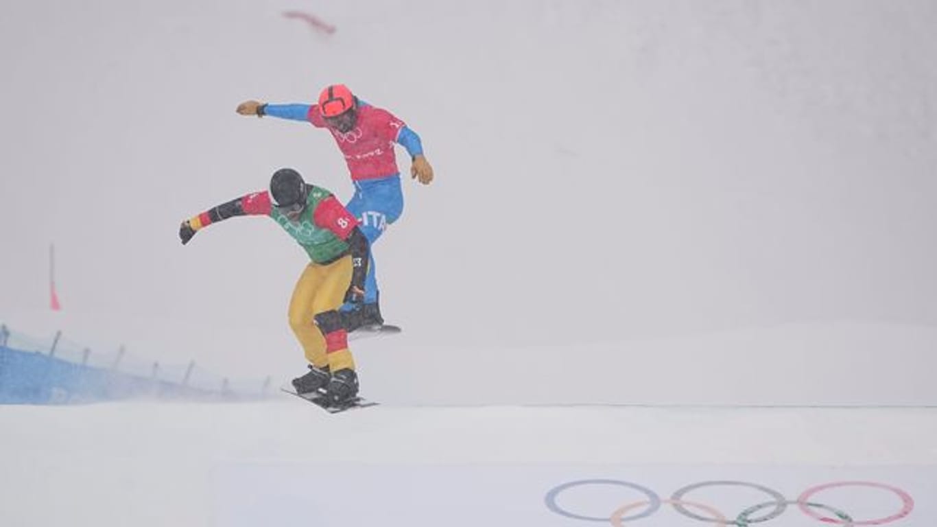 Snowboardcrosser Martin Nörl (l) rast beim Team-Wettbewerb über die Piste.