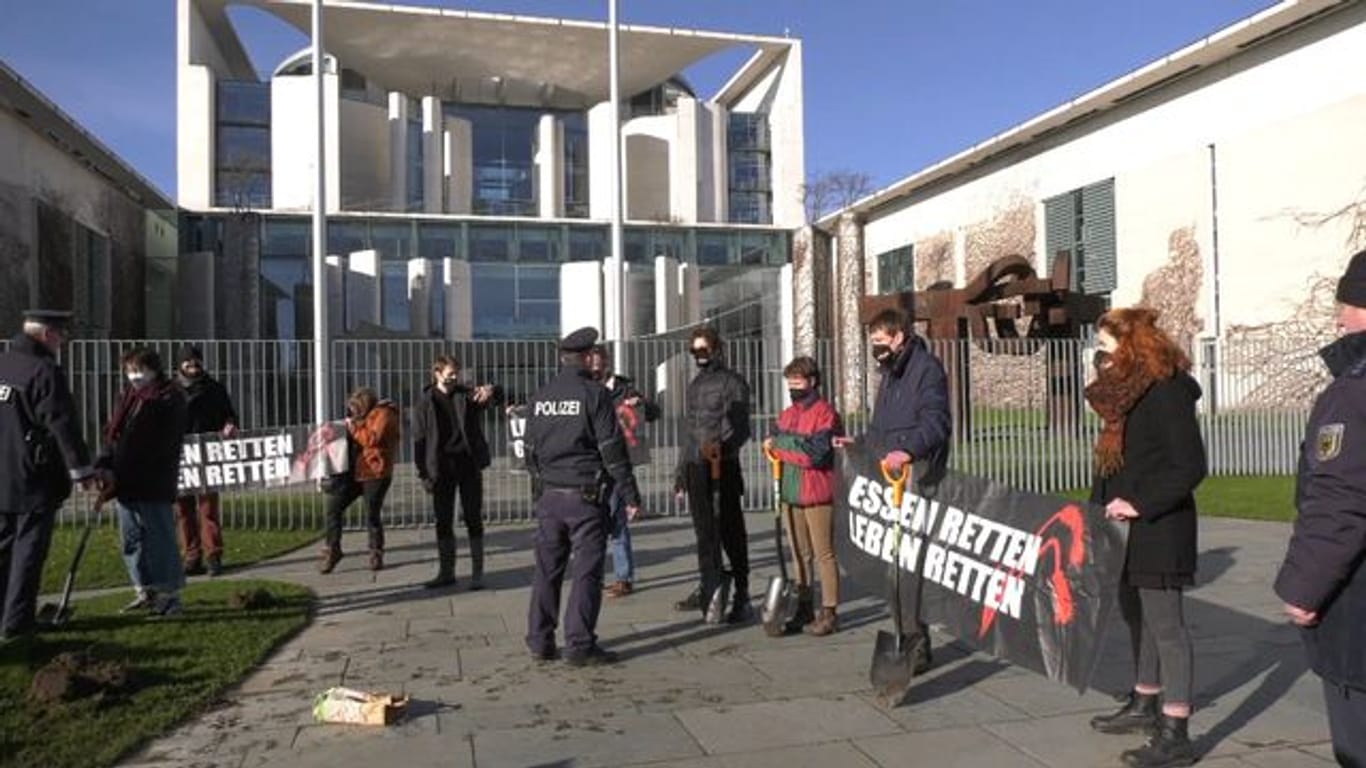 Klimaschützer der Gruppe "Aufstand der letzten Generation" pflanzen vor dem Amtssitz von Bundeskanzler Scholz Kartoffeln.