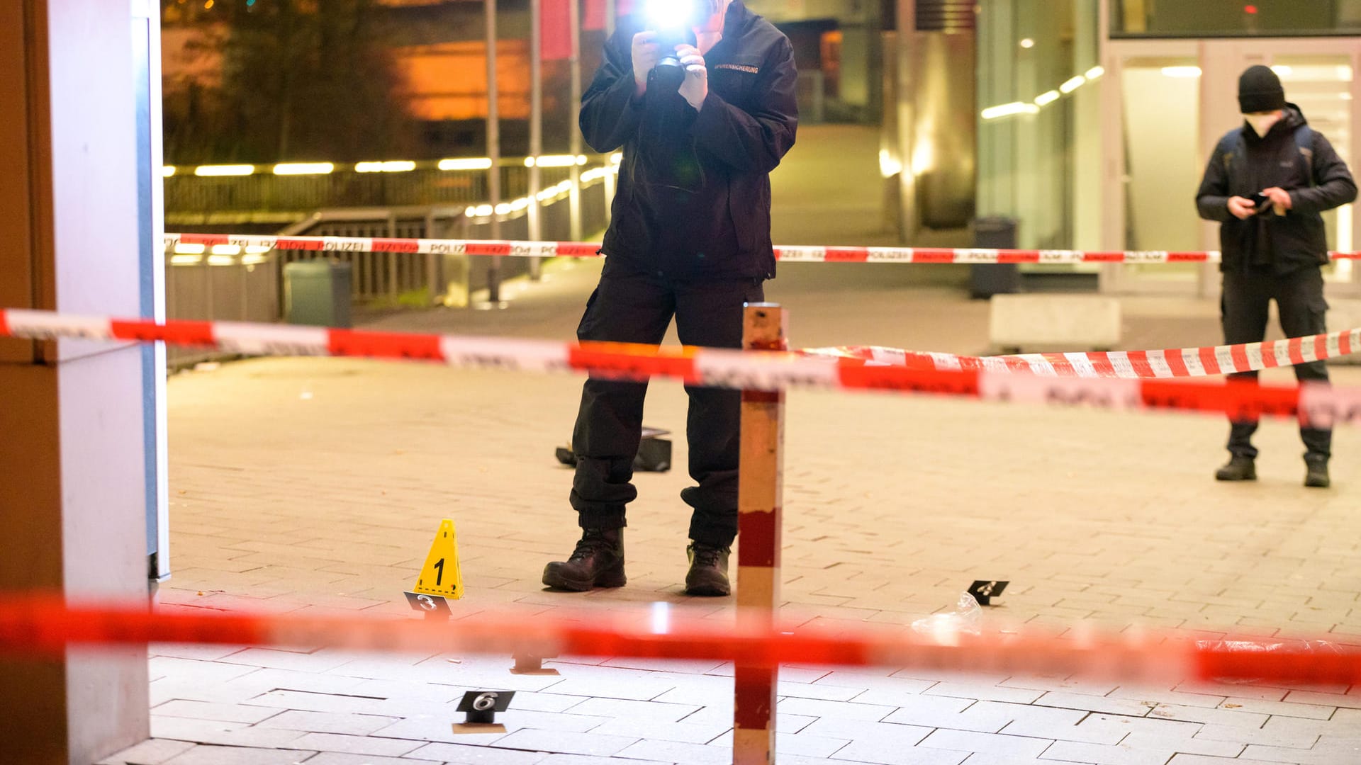 Kriminaltechniker ermitteln am abgesperrten Fundort des Verletzten vor einem Einkaufszentrum: Ein Mann wurde bei einem Messerangriff verletzt. Kriminaltechniker ermitteln am abgesperrten Fundort des Verletzten vor einem Einkaufszentrum: Ein Mann wurde bei einem Messerangriff verletzt.