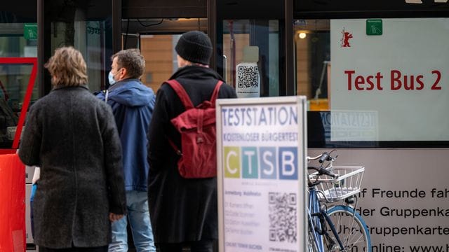 Menschen warten während der Berlinale vor einem Corona-Test-Bus am Potsdamer Platz.