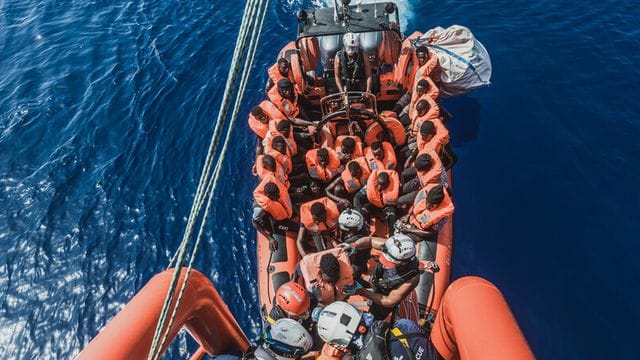 Gerettete Migranten sitzen in einem Schlauchboot der Rettungsorganisation "Ocean Viking" (Archivbild).