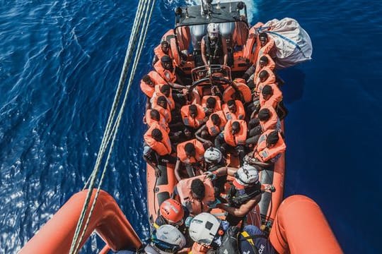 Gerettete Migranten sitzen in einem Schlauchboot der Rettungsorganisation "Ocean Viking" (Archivbild).