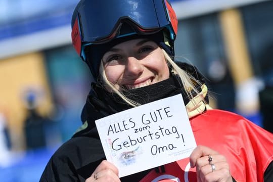 Aliah Delia Eichinger hält ein Schild mit der Aufschrift "Alles Gute zum Geburtstag Oma!" in die Kamere.