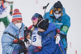 Ingrid Landmark Tandrevold: Helfer des Teams tragen die zusammengebrochene Biathletin aus dem Zielbereich.