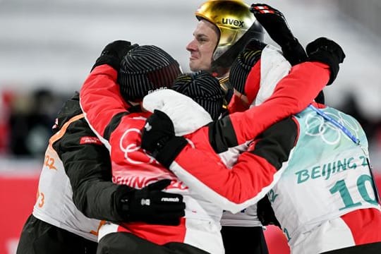 Karl Geiger (hinten) feiert mit seinen Teamgefährten Markus Eisenbichler (l), Constantin Schmid (2.