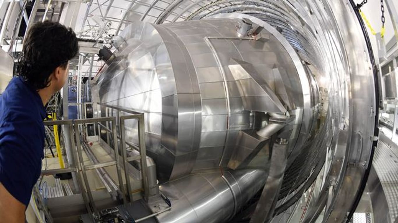 Ein Mitarbeiter des Karlsruher Tritium Neutrino Experiments (Katrin) am Karlsruher Institut für Technologie (KIT) blickt auf das Hauptspektrometer der Anlage.