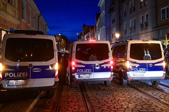 Einsatzfahrzeuge der Polizei blockieren eine Straße