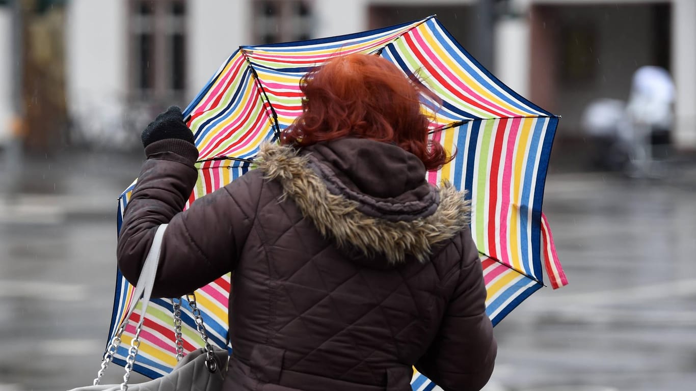 Eine Frau mit Regenschirm (Archivbild): In Nordrhein-Westfalen wird es stürmisch.